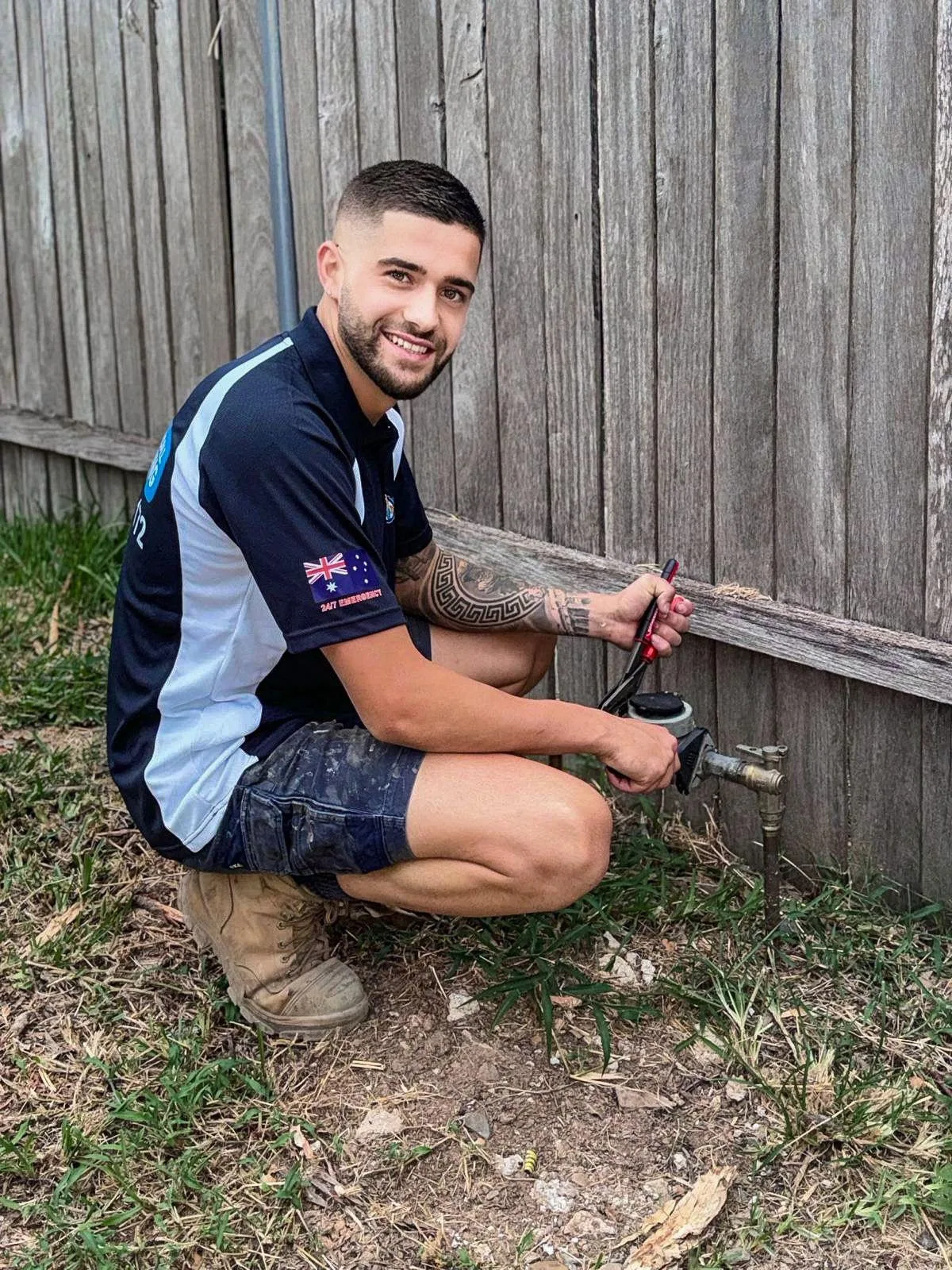 Plumber at an outdoor tap and garden drainage point